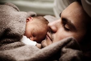 man with baby sleeping